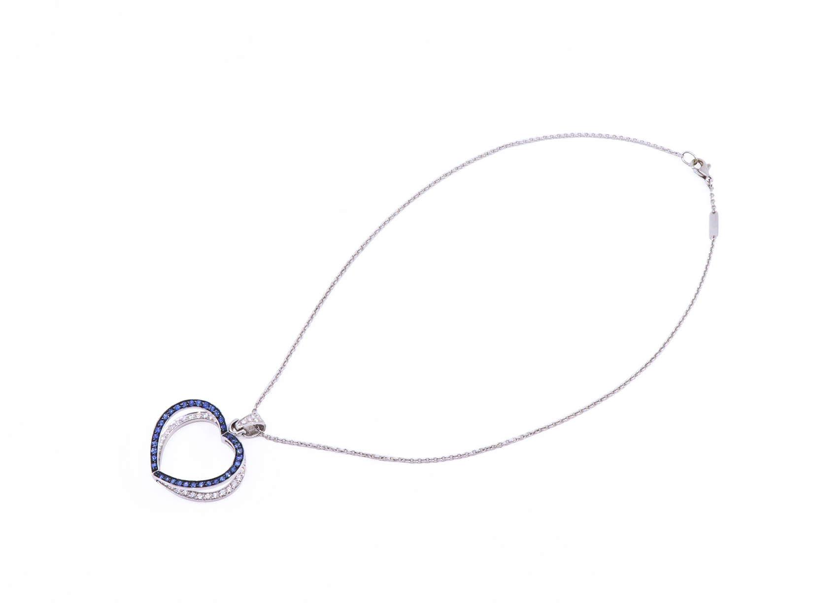 Collana in oro bianco con ciondolo due cuori sovrapposti zaffiri e brillanti.